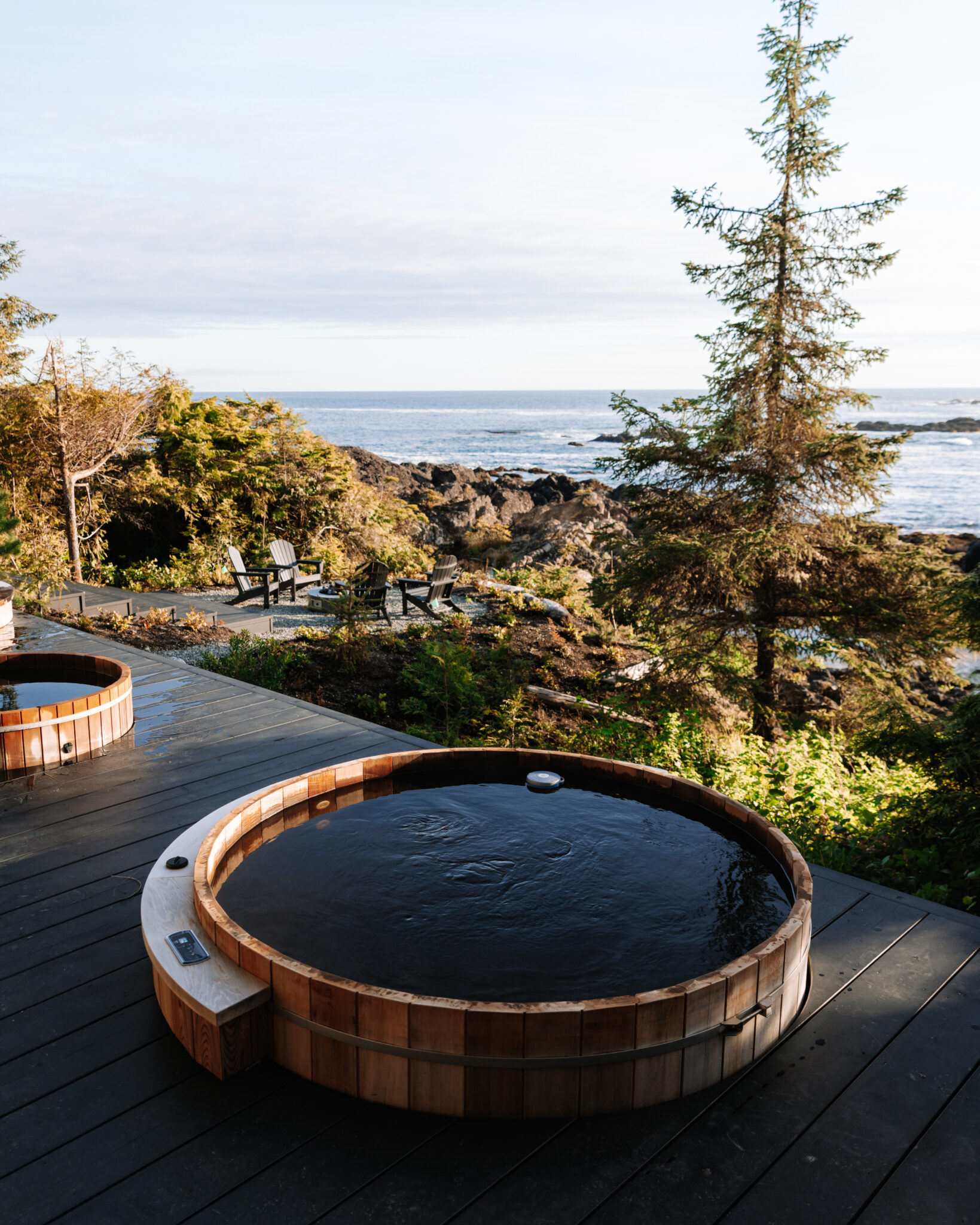 Cedar hot tubs at The Nami Project, overlooking the Pacific Ocean with a coastal forest backdrop